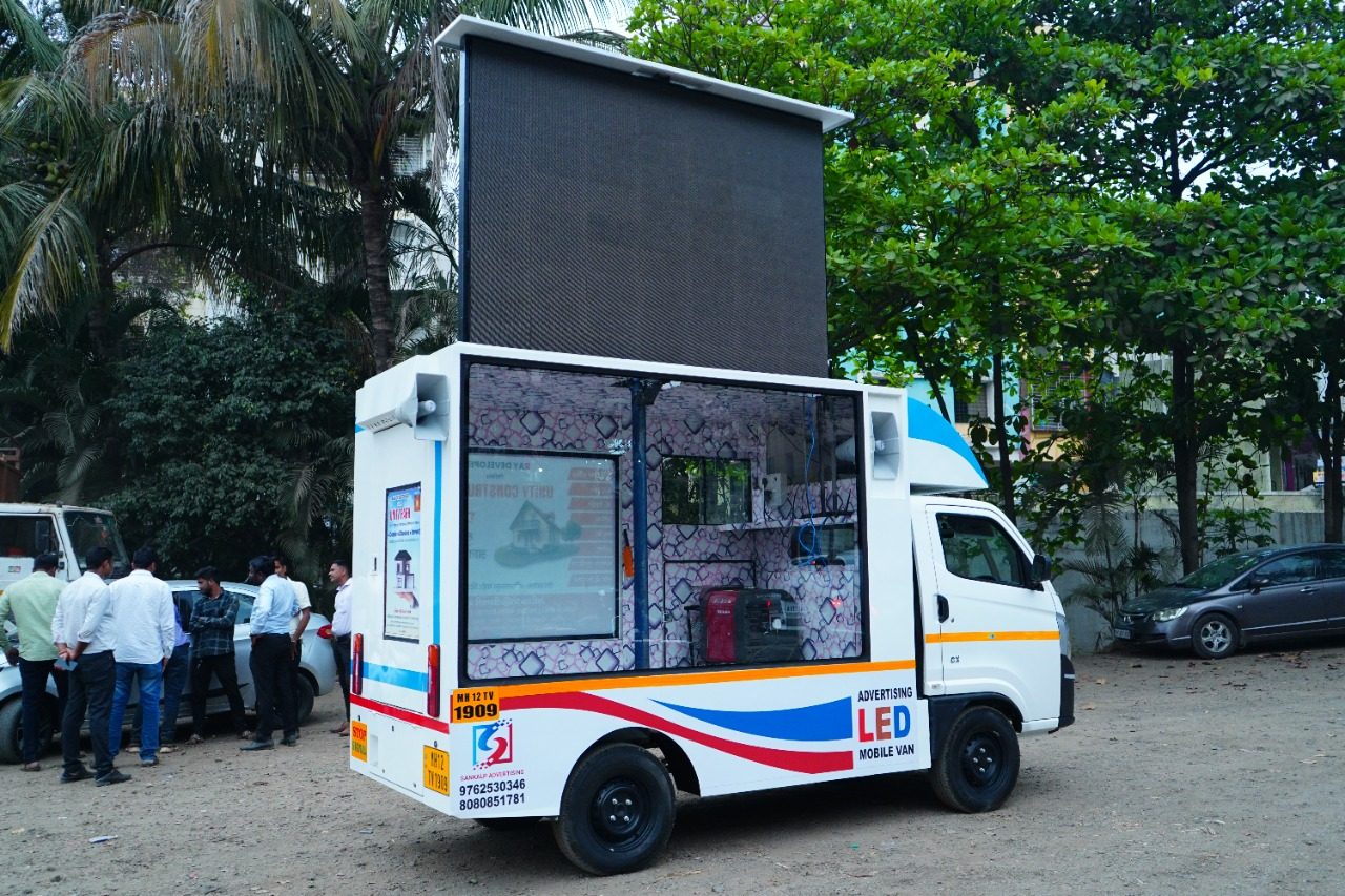 Mobile LED screen van glowing on a city street at night
